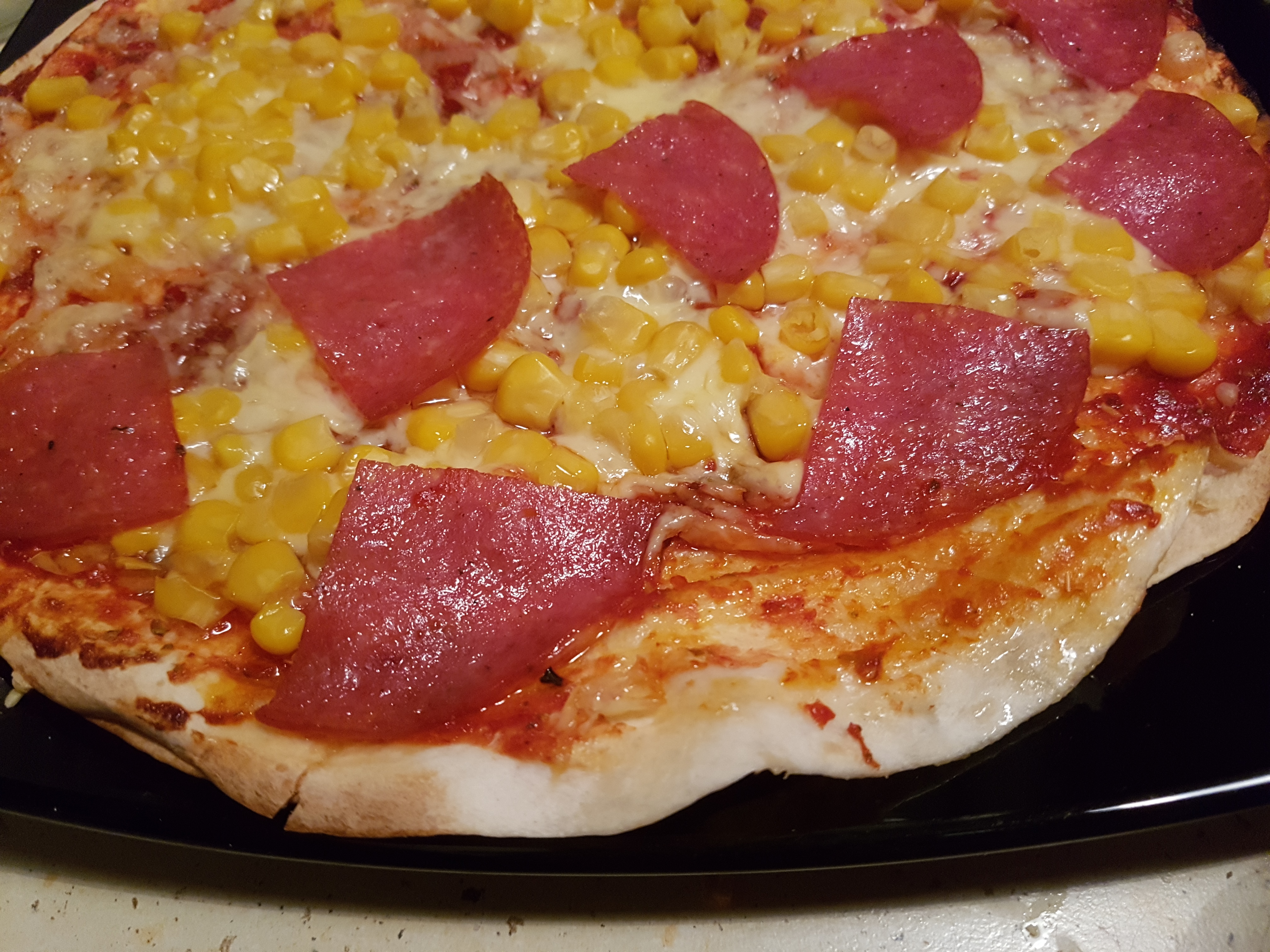 pizza na placku do tortilli z serem, salami i kukurydzą